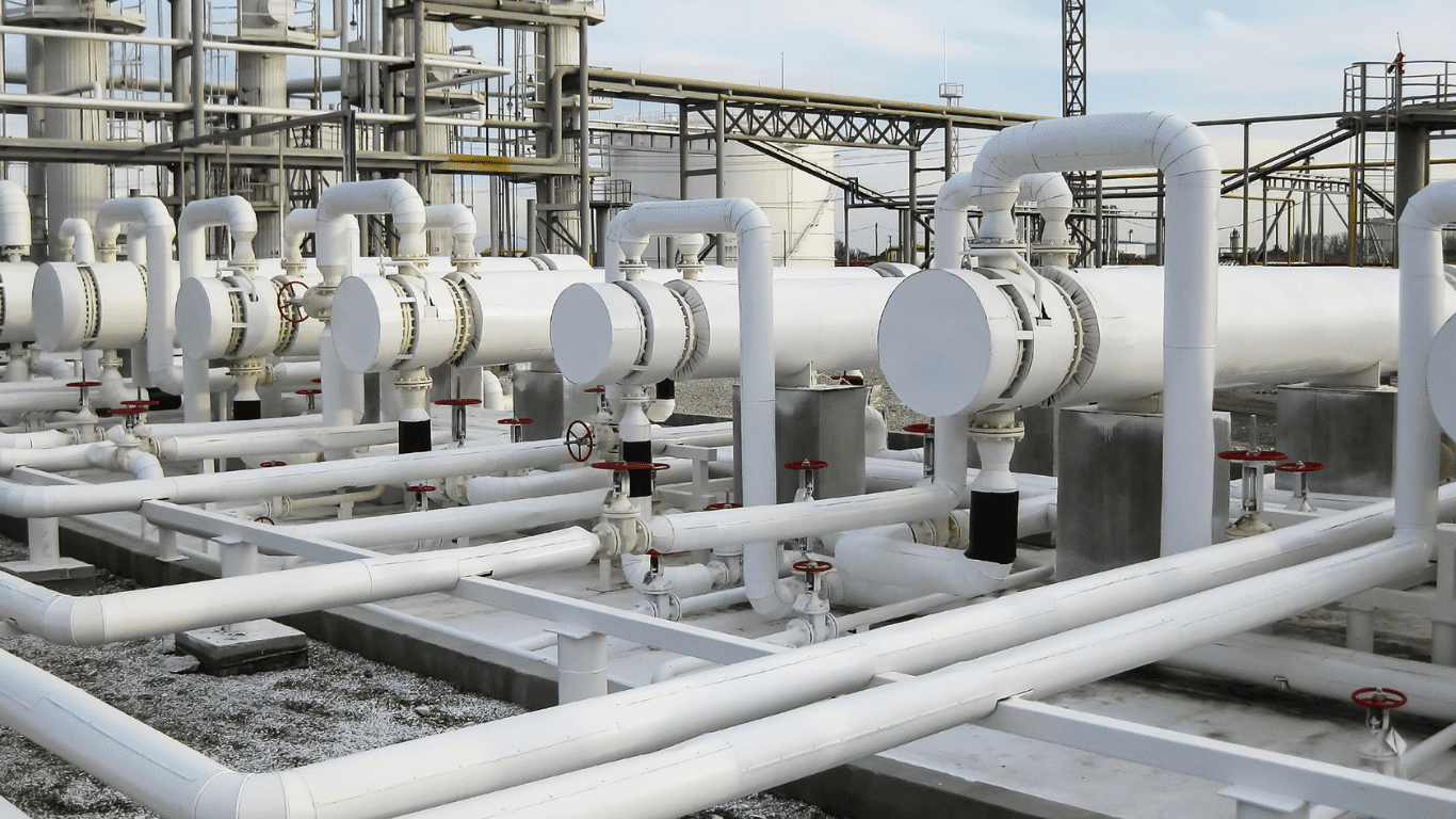 Industrial shell-and-tube heat exchanger system illustrating the fundamentals of heat transfer in large-scale water infrastructure, demonstrating heat and mass transfer principles used in mechanical engineering and studied at the university level by students learning the fundamentals of heat. The image shows how heat moves from a higher temperature fluid to a lower temperature fluid due to a temperature difference and resulting temperature gradient, causing heat flows through conduction convection and radiation. Within the exchanger, fluids in liquid or gas form transfer energy across a metal solid surface, where thermal conductivity of the material, surface properties, and total surface area determine how efficiently the system can transfer heat.  This setup provides a real-world example of thermal energy processes in industry, where conduction occurs through the metal wall in physical contact with a solid, convection (including forced convection from pumps and free convection driven by density changes) circulates warmer and cooler molecules in air, water, or other liquid media, and radiation or thermal radiation enables energy exchange through electromagnetic light even across space, similar to how the sun transfers energy to the earth and the surrounding environment. Inside the exchanger, energized molecules exhibit random movements, colliding with adjacent molecules and transferring energy from a hot region to a cooler region, which can be expressed through mathematical representation, simplified in one dimensional steady-state models, or solved using analytical solutions in advanced engineering analysis.  The image reflects a controlled or partially closed system where a heat source supplies energy, and engineers measure performance to calculate thermal effectiveness, accounting for fluid properties, flow conditions, and other forms of energy exchange including mass transfer occurring simultaneously with heat transfer. Such systems highlight how a body of fluid can absorb energy and later release it through emission, impacting efficiency and overall environmental impact. This visual could accompany a textbook chapter on the fundamentals of thermal science, showing how differences in temperature drive energy transfer across solid, liquid, and gas phases, reinforcing the core concepts of heat and mass transfer that enable safe, reliable, and efficient industrial operations.