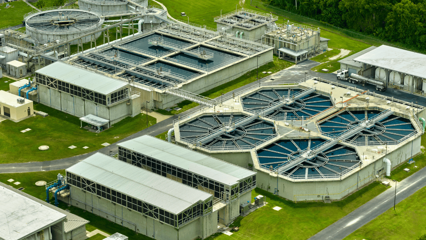 Aerial view of large industrial wastewater treatment systems operating at a manufacturing facility, showing multiple clarifiers, aeration basins, and filtration units designed for industrial wastewater treatment and advanced wastewater treatment systems that handle high volumes of industrial wastewater through integrated treatment systems and specialized treatment technologies. These industrial wastewater treatment systems support complete industrial wastewater treatment processes, where industrial wastewater flows through a multi-stage process beginning with primary treatment that removes suspended solids, followed by secondary treatment biological stages that reduce biochemical oxygen demand and improve overall wastewater treatment performance. The facility demonstrates how modern industrial wastewater treatment facilities use multiple treatment processes and treatment solutions to treat wastewater generated by manufacturing and heavy industry while protecting the environment.  Within these industrial wastewater treatment systems, engineers apply a carefully managed process that integrates mechanical separation, biological reactors, and filtration technologies to ensure reliable wastewater treatment and safe handling of industrial wastewater streams. During the early process stage, primary treatment equipment captures debris and removes suspended solids while also assisting with removing oils and other contaminants from industrial wastewater before it continues through additional industrial wastewater treatment processes. These treatment processes represent proven industrial wastewater treatment methods used across modern wastewater treatment systems designed to improve compliance and sustainability while minimizing environmental impact on the surrounding environment.  As the process continues, secondary treatment uses biological activity to reduce organic load and lower biochemical oxygen demand, improving the effectiveness of industrial wastewater treatment and enabling safer reuse of treated water. This stage is an essential part of industrial wastewater treatment systems because it converts waste compounds into manageable byproducts through biological treatment technologies that support efficient wastewater treatment. Throughout this process, facility operators monitor system performance to ensure reliable treatment systems operation and consistent removal of contaminants from industrial wastewater streams.  After biological treatment, advanced filtration steps within the industrial wastewater treatment facility refine the water through a final process stage that uses sand filter beds and membrane filtration units to further polish the effluent. These treatment systems rely on membrane filtration, sand filter technology, and other modern treatment technologies to capture remaining particles and ensure the wastewater treatment process achieves regulatory standards. In many industrial wastewater treatment systems, reverse osmosis is added as an additional process step that removes dissolved contaminants and supports high-quality water recycling for industrial operations. This combination of membrane filtration, sand filter stages, and reverse osmosis represents advanced industrial wastewater treatment methods used to optimize industrial wastewater treatment performance.  Specialized chemical treatment may also be incorporated into industrial wastewater treatment processes, where dosing systems introduce other chemicals and corrosion control agents to manage scale buildup and improve overall treatment processes efficiency. In certain industrial wastewater treatment systems, technologies such as ion exchange are used alongside membrane filtration and reverse osmosis as part of the integrated process to remove dissolved ions from industrial wastewater and enhance reuse potential. These combined treatment technologies allow facilities to transform contaminated industrial wastewater into usable water resources through carefully engineered treatment systems.  The final process stage in many industrial wastewater treatment facilities includes a polishing step that ensures the highest level of water quality before discharge or reuse. During this stage, advanced membrane filtration, additional sand filter units, and sometimes ion exchange equipment provide final purification within the wastewater treatment systems. This process supports water recycling programs that allow treated water to be safely reused for cooling, cleaning, or other industrial operations, greatly increasing the sustainability of industrial wastewater treatment systems while protecting the environment.  Through the integration of multiple treatment systems, modern industrial wastewater treatment plants can efficiently treat wastewater produced by manufacturing facilities while maximizing reuse opportunities. Each process stage—from primary treatment and secondary treatment to filtration and reverse osmosis—forms a comprehensive network of industrial wastewater treatment systems designed to transform contaminated industrial wastewater into water suitable for discharge or reuse. By combining advanced treatment technologies, proven industrial wastewater treatment processes, and optimized treatment solutions, these facilities deliver reliable wastewater treatment that reduces pollution, improves water recycling, and protects the surrounding environment.