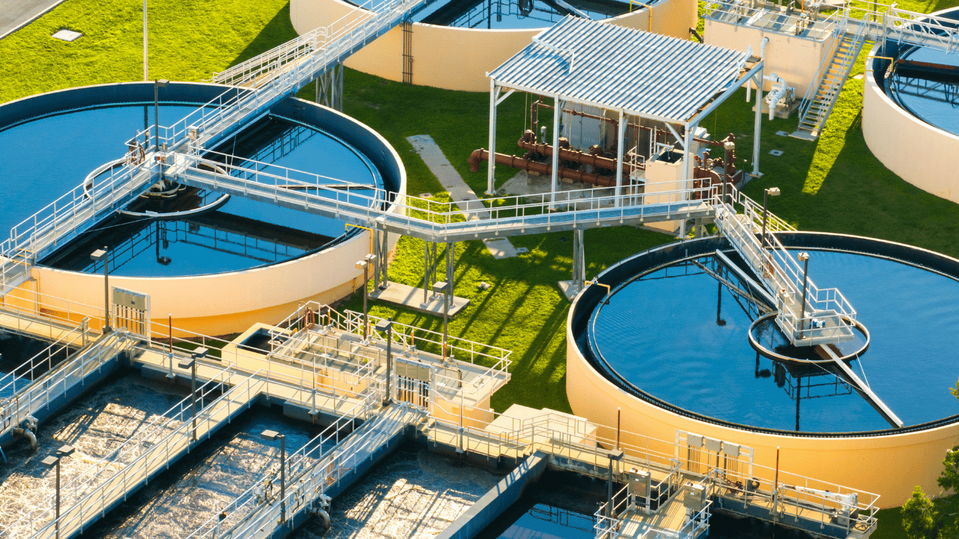 A modern industrial water treatment facility showing circular clarifiers and advanced water treatment processes used in industrial water treatment and wastewater treatment, where water treatment chemicals and industrial water treatment chemicals like aluminum sulfate, ferric chloride, and polyaluminum chloride act as effective coagulants to remove suspended solids and suspended particles from wastewater, helping in treating wastewater from industrial facilities and manufacturing processes; systems also use sodium hypochlorite and chlorine to kill bacteria, other pathogens, and organic matter, while hydrogen peroxide supports oxidation, ensuring treated water meets standards, protects equipment, and supports corrosion control on metal surfaces, boiler internals, and heat transfer surfaces in cooling towers by reducing corrosion rates, mineral deposits, and heavy metals through corrosion inhibitors, scale inhibitors, oxygen scavengers, and other treatment chemicals, making the treatment process essential, cost effective, and crucial for various industries to ensure compliance and reduce environmental impact.