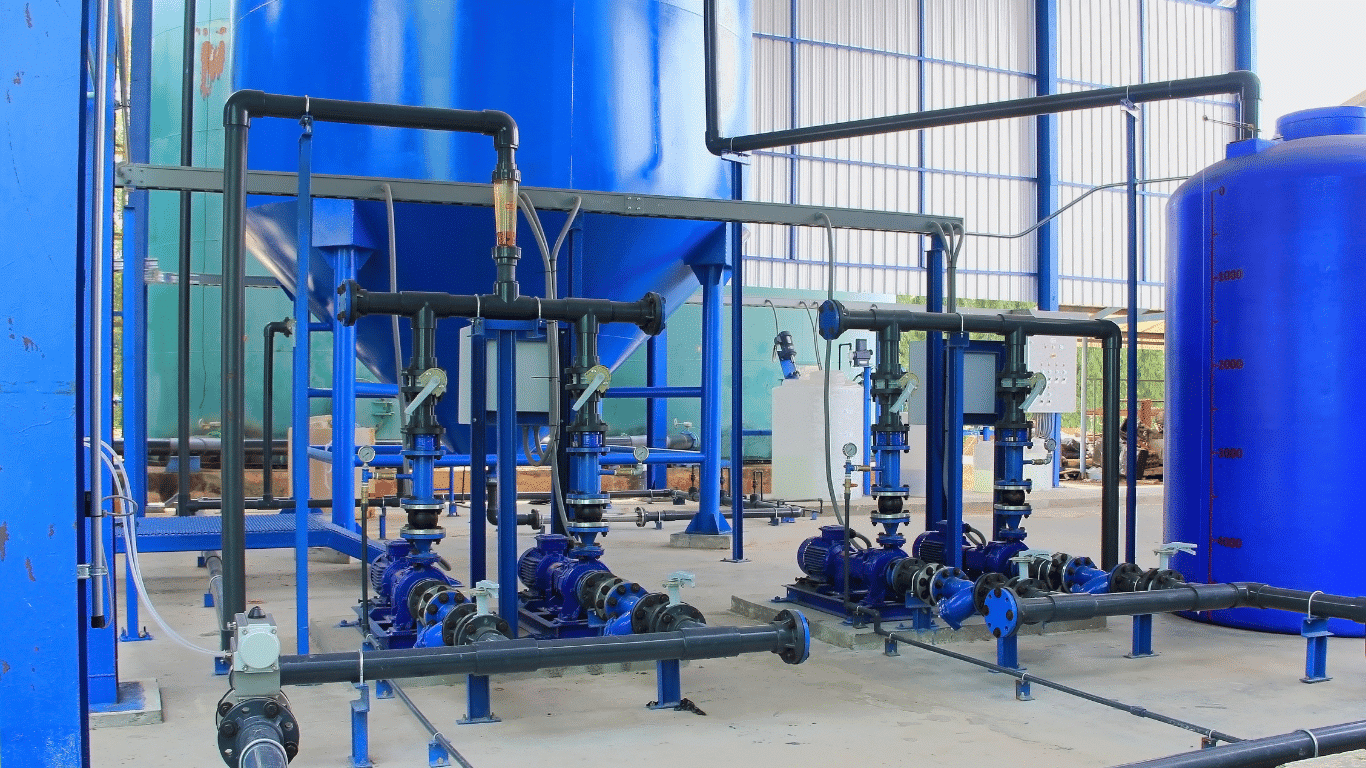 Engineered commercial water softener systems in an industrial water treatment facility with blue tank vessels, pumps, pipes, and resin controls supporting industrial water softening applications for cooling towers, boiler feeds, heat exchange systems, car washes, and other commercial and industrial applications. These water softening systems maintain continuous flow, stable water flow, and high flow rates for commercial water and industrial water process equipment used across industries.