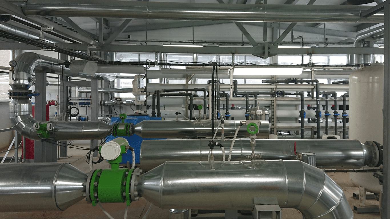 Industrial water treatment facility with stainless steel piping and advanced membrane filtration systems operating under pressure, showcasing membrane filtration technologies like reverse osmosis membranes and ultrafiltration membrane units that act as a physical barrier to separate particles, bacteria, viruses, and other contaminants from liquid streams, improving water quality and drinking water safety through efficient filtration, controlled flow, and optimized membrane pore size.