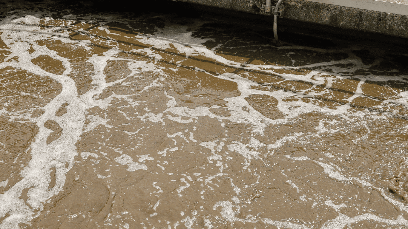 Foamy mine water flowing through an industrial wastewater treatment plant, illustrating mining wastewater treatment solutions for treating mining wastewater. The image represents mine water treatment used at mining sites and mining operations to remove suspended solids, heavy metals, organic compounds, and other specific contaminants from mining influenced water and contaminated water. These wastewater treatment systems support water treatment, water quality, safe discharge, water reuse, and environmental compliance while helping protect water resources and reduce the environmental impact of the mining industry.
