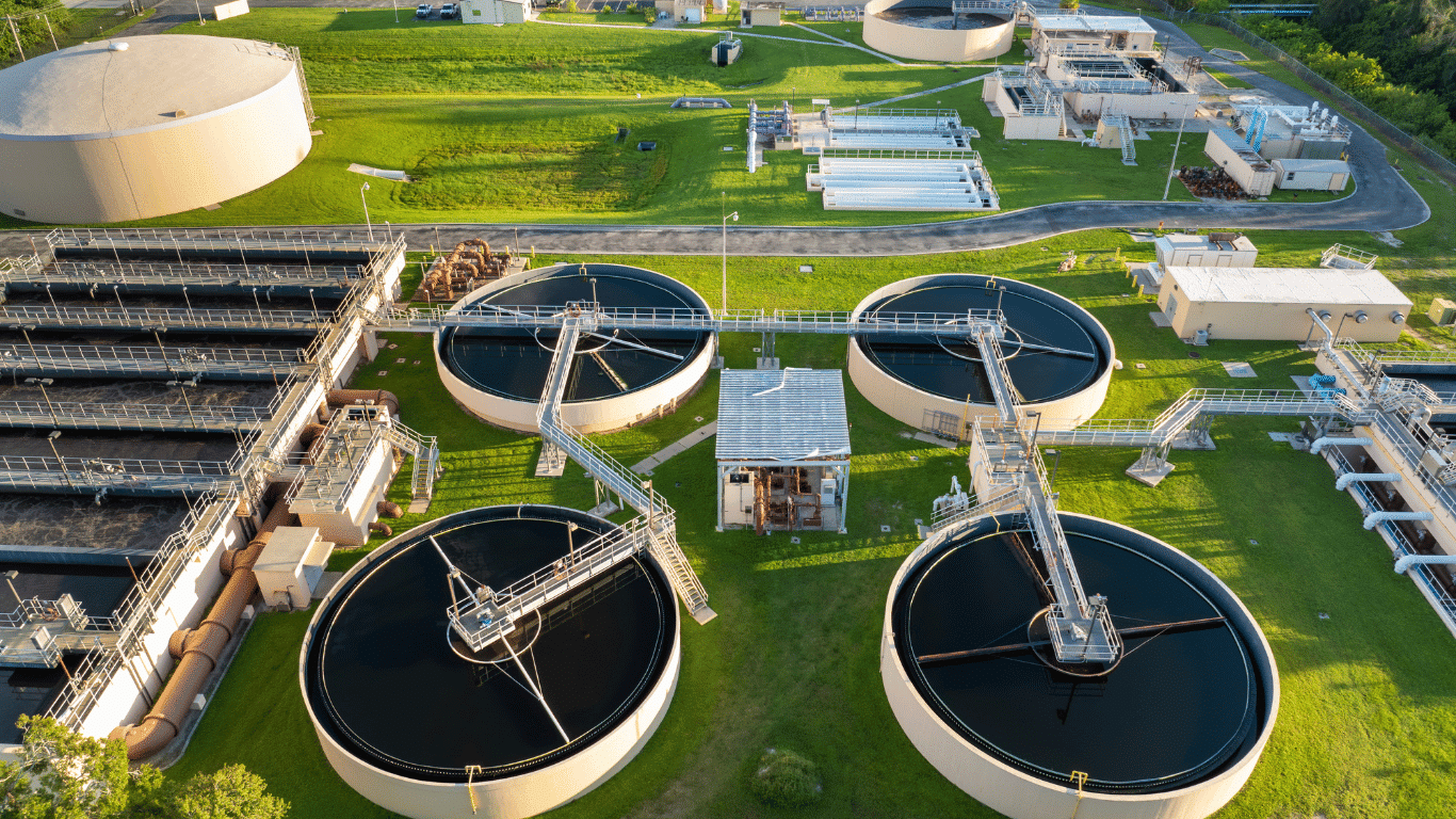 Aerial view of modern water treatment plants featuring circular clarifiers and advanced water treatment systems supporting sustainable water treatment solutions, wastewater treatment, water treatment processes, and sustainable water management. The facility demonstrates energy efficient technologies, automated chemical feed systems, membrane filtration, advanced oxidation processes, and water reuse to improve water quality, drinking water, potable water, and clean water while reducing energy consumption and the environmental footprint.