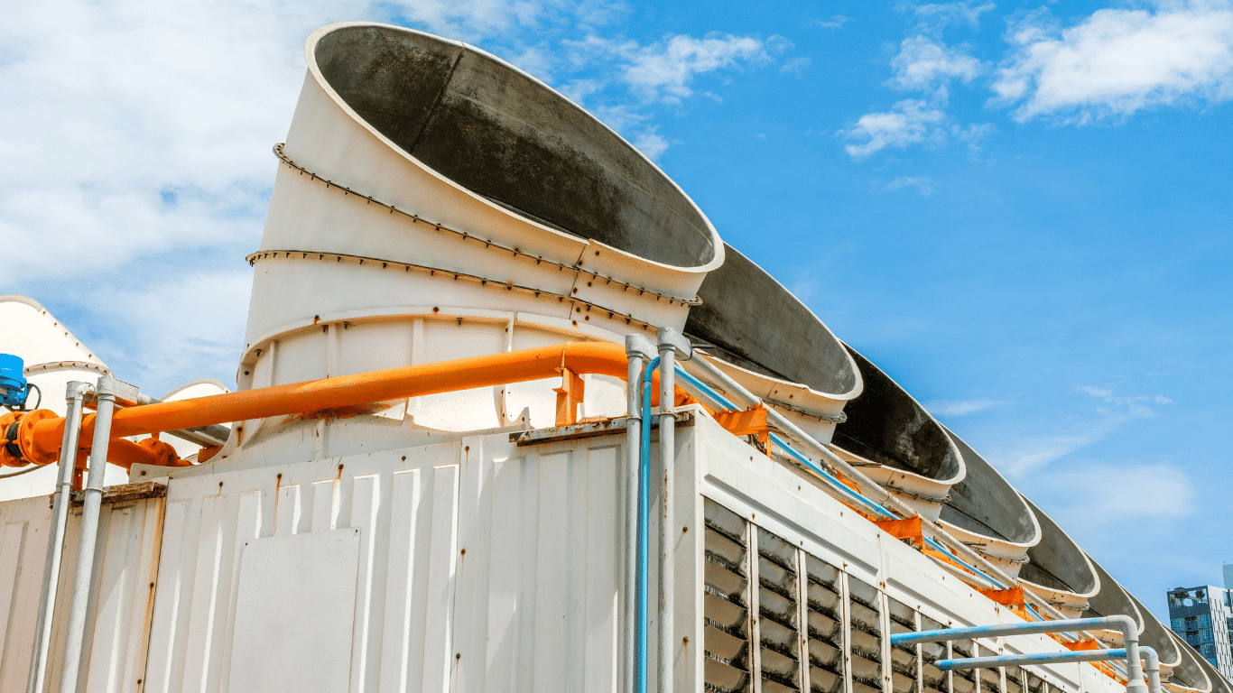 Industrial cooling towers with large air ducts and piping, illustrating cycles of concentration, cooling tower water, makeup water, and cooling tower system operation.
