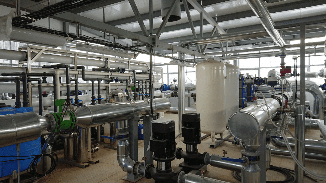 Industrial water treatment system with stainless-steel pipes, pumps, filtration equipment, and treatment tanks for food and beverage production.